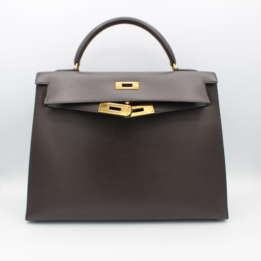 Dark gray handbag with gold hardware on a white background